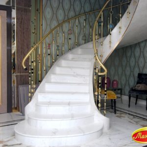Изогнутая бетонная лестница на тетивах с облицовкой ступеней и подступенков натуральным мрамором
