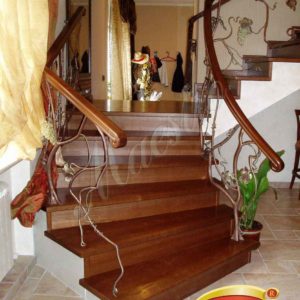 Монолитная лестница с облицовкой и ограждением с художественной ковкой