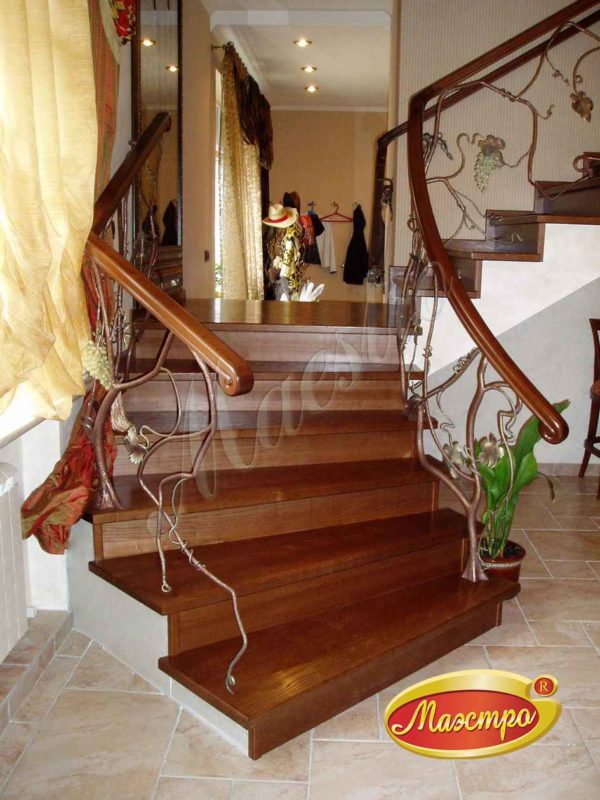Монолитная лестница с облицовкой и ограждением с художественной ковкой
