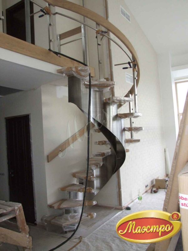 Винтовая лестница из стали и дерева в процессе монтажа