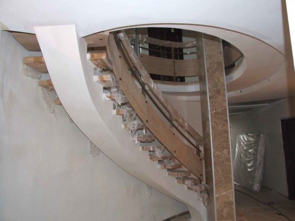 Изогнутая лестница на второй этаж на бетонном косоуре